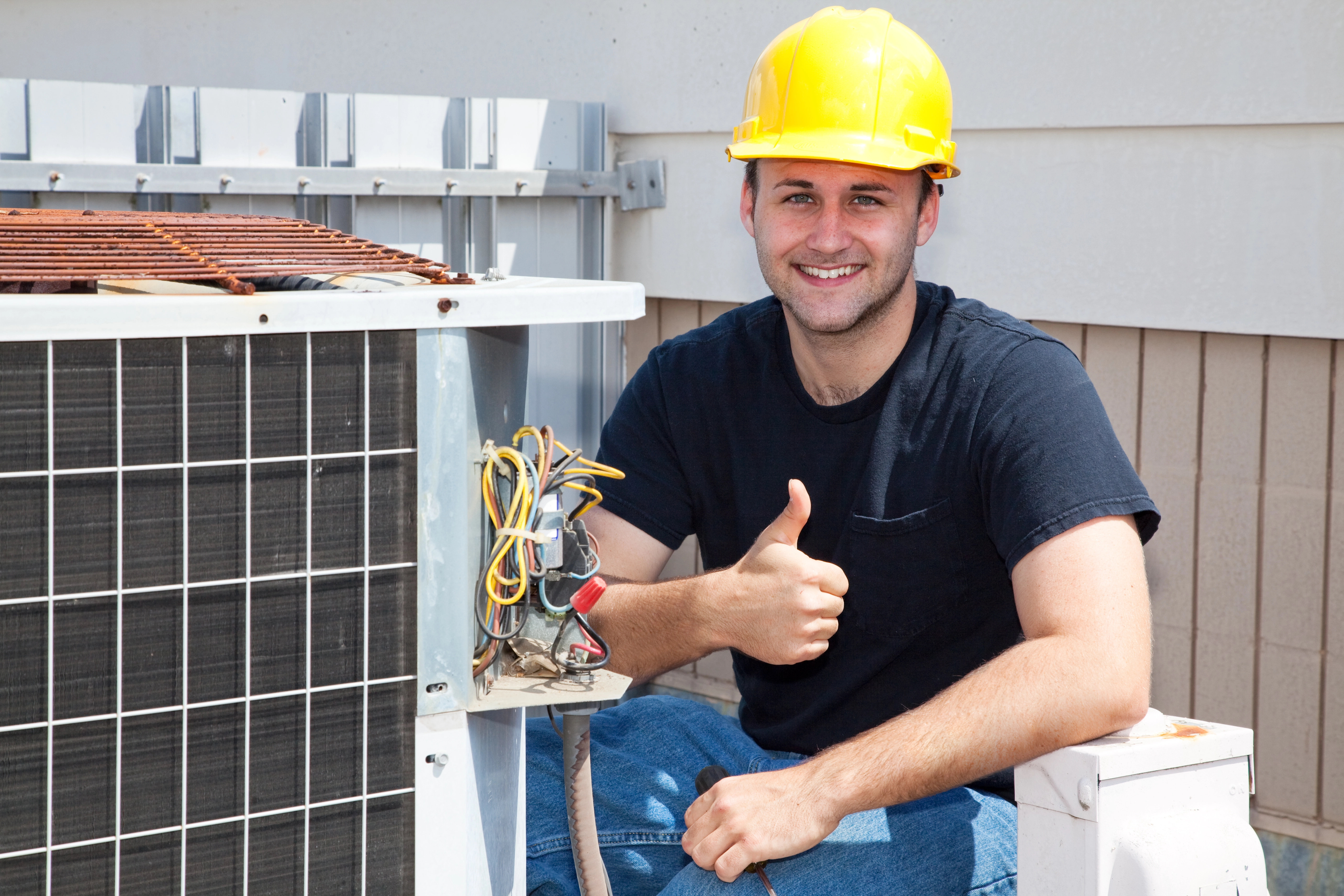 HVAC technician giving thumbs up after completing air conditioner repair