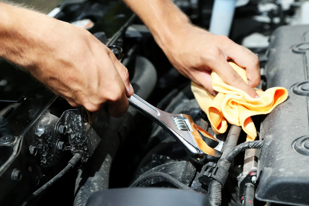Auto mechanic holding a wrench working on a vehicle in a repair shop