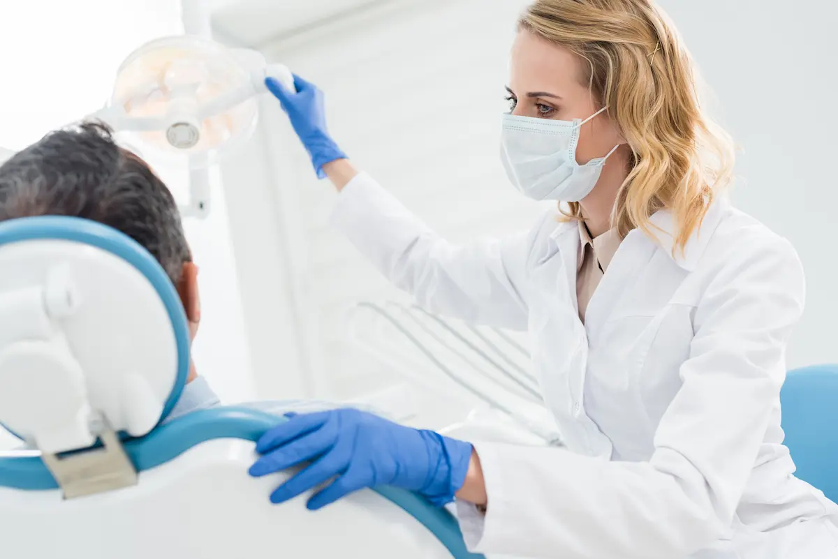 Dentist adjusting the overhead lamp in a modern dental treatment room