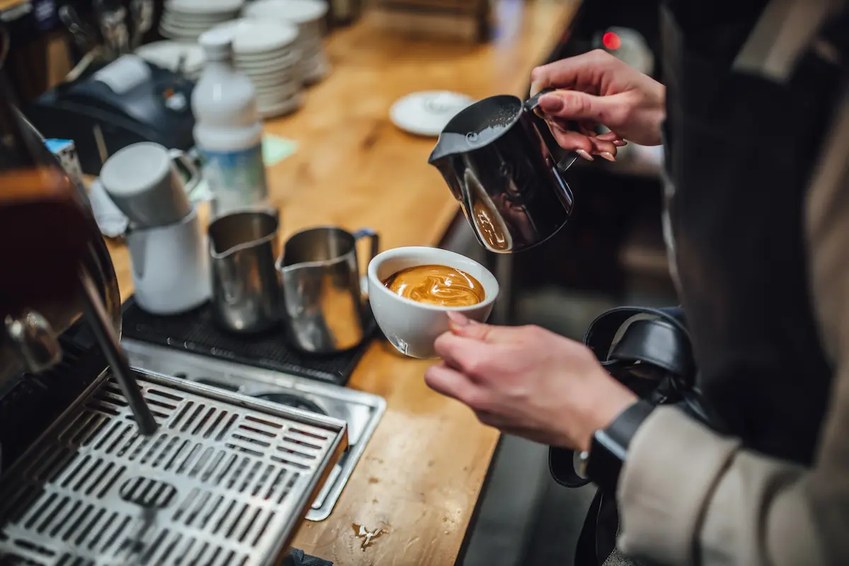 Skilled barista crafting a cappuccino at an independent coffee shop