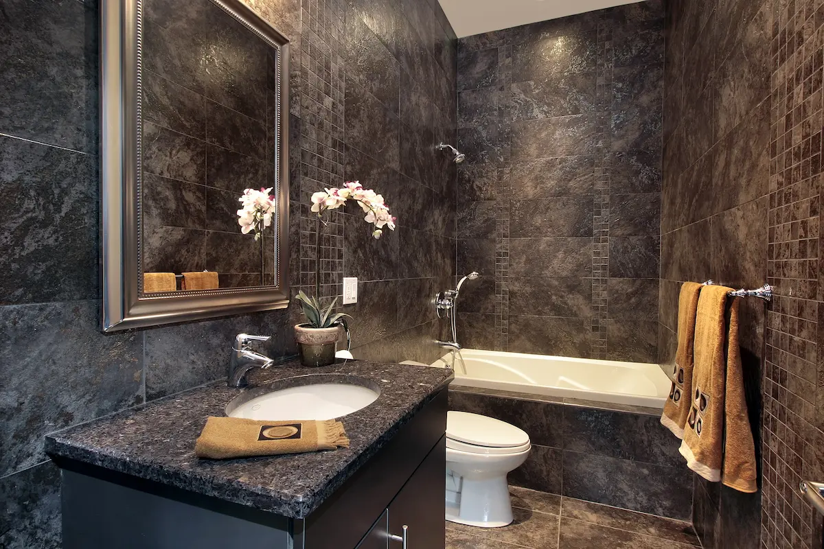 Elegant powder room featuring dramatic black granite wall installation