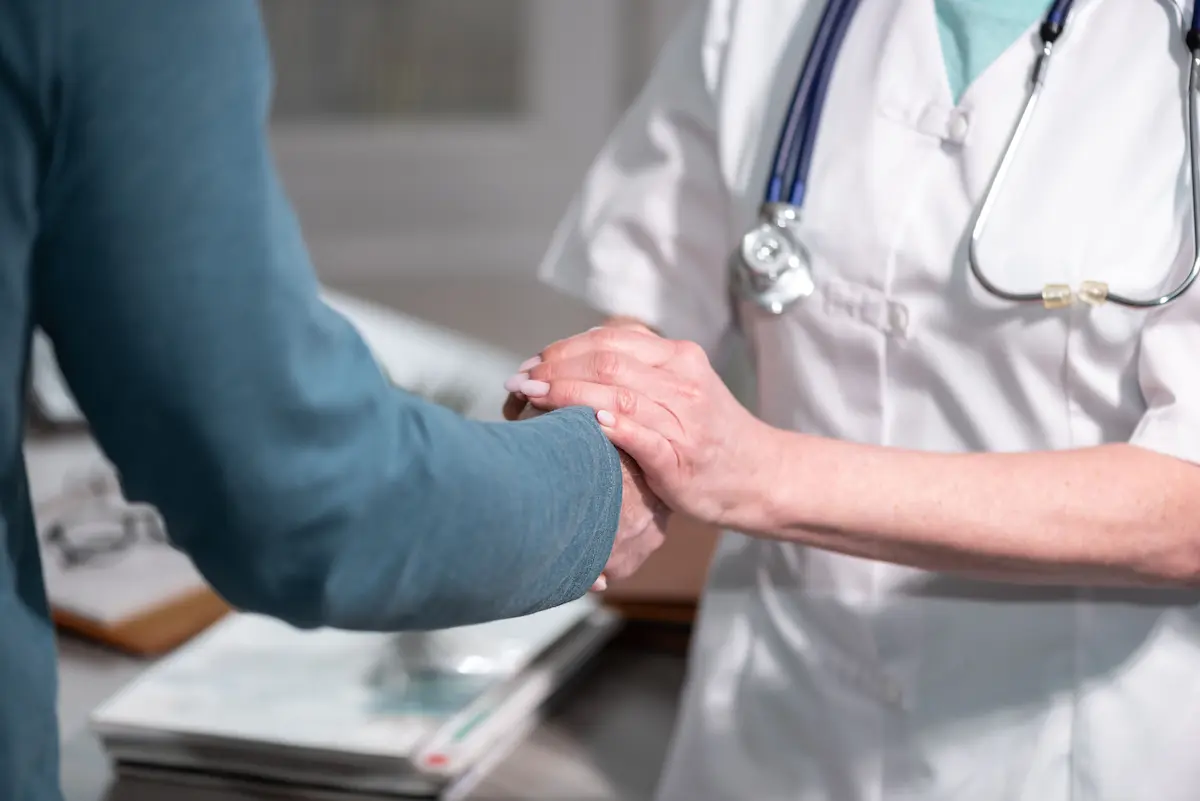 Female doctor holding patient hand in encouragement during a wound care consultation