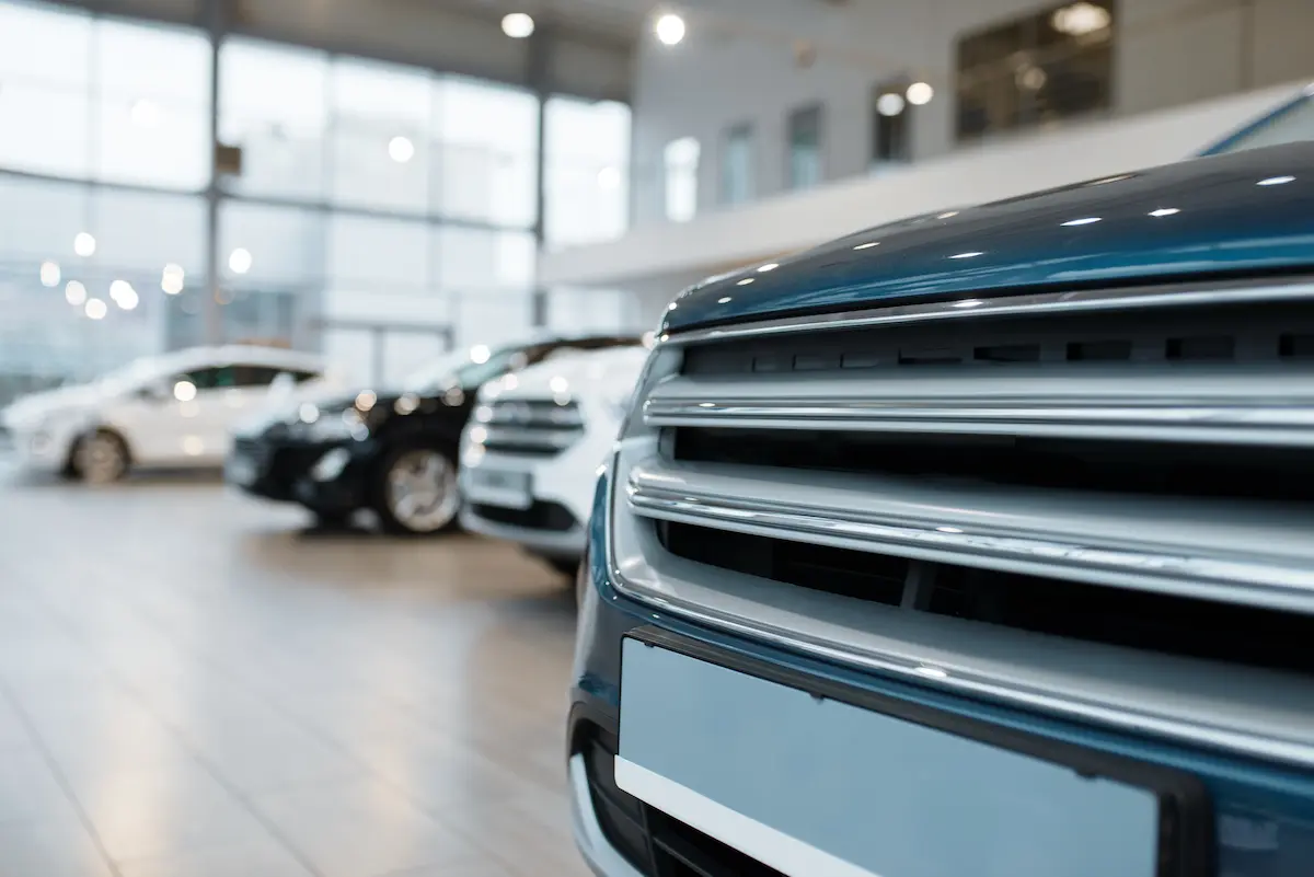 Closeup view of an automobile radiator grille and front end at a new vehicle dealership showroom