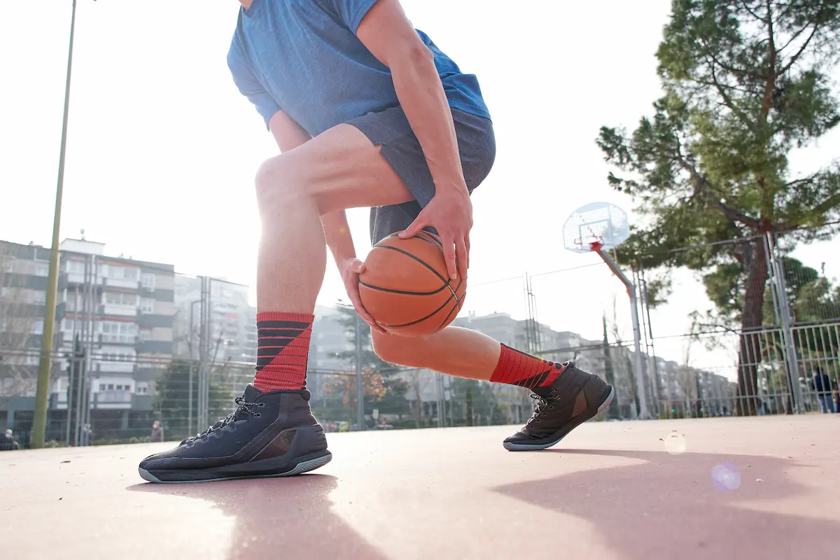 Young basketball player dribbling on an outdoor court during a training session with focused skill development activity