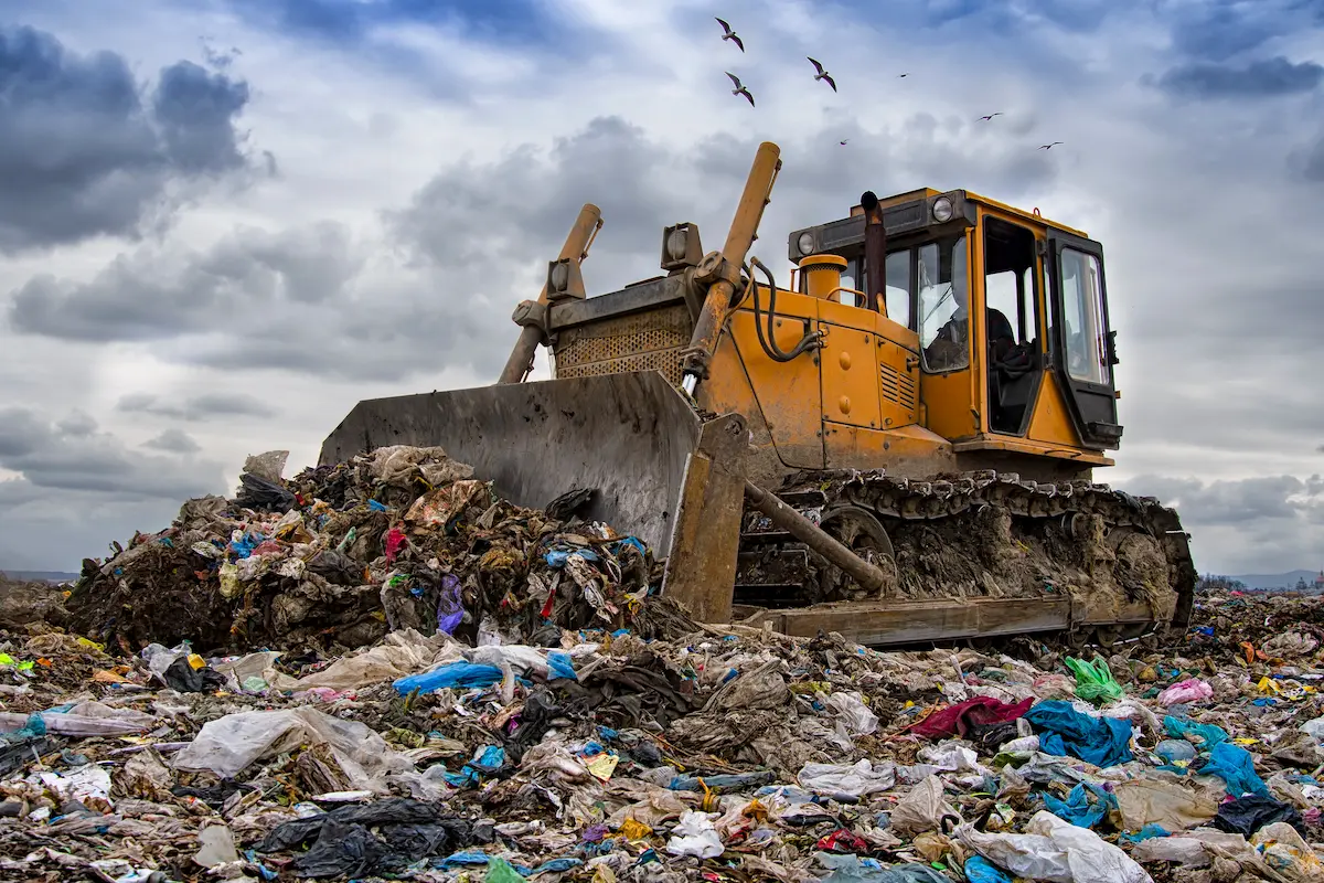 Heavy equipment bulldozer working at a waste management and disposal facility site