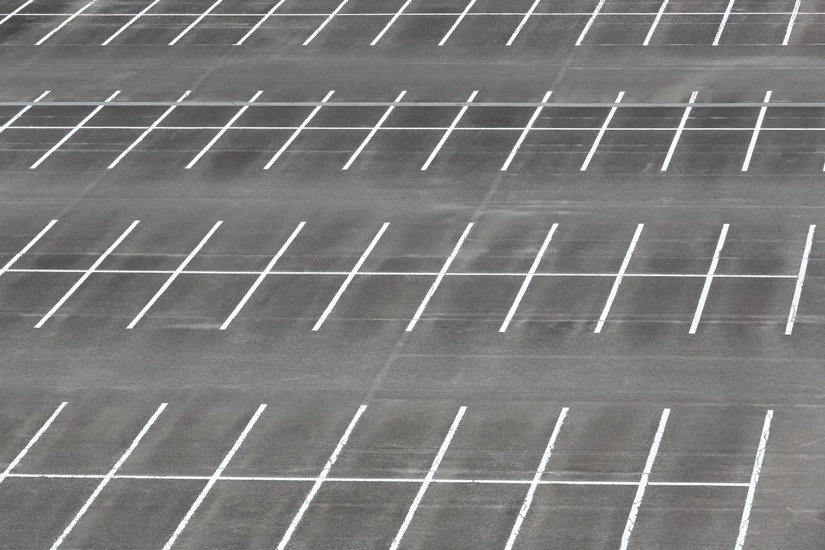 Empty commercial parking lot with fresh crisp striping and parking space markings representing professional parking lot striping services