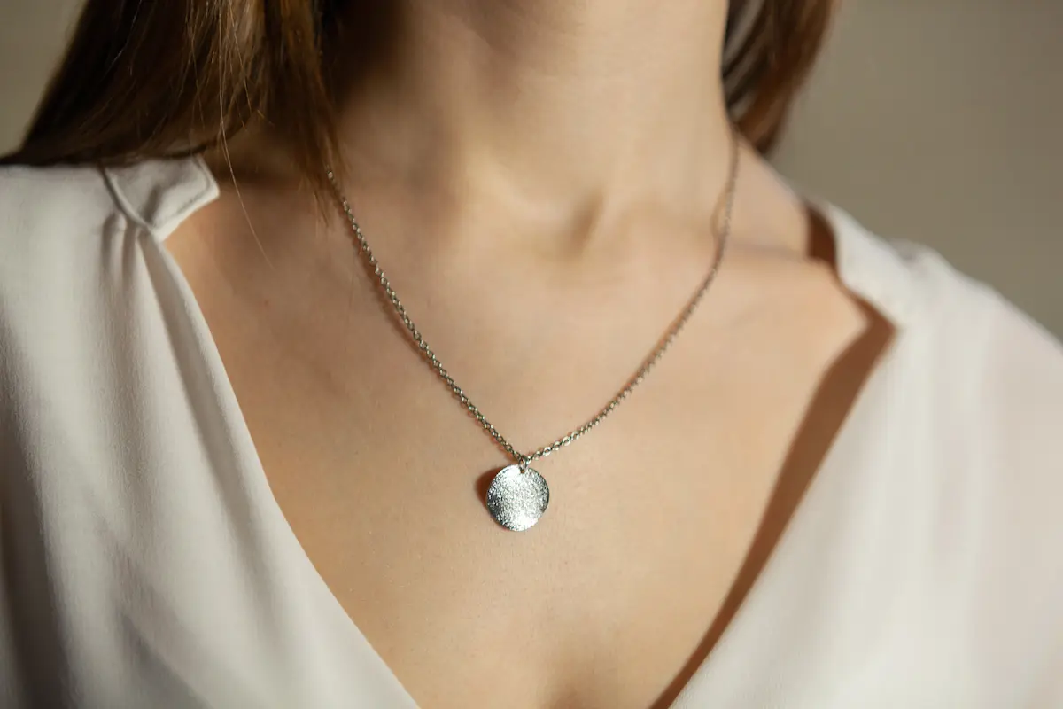 Portrait of a woman wearing delicate fine jewelry representing the elegance and personal expression that permanent jewelry provides for every client
