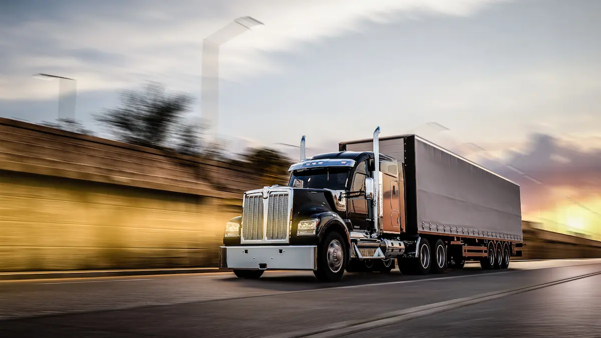American style semi-truck pulling a load on the freeway representing the commercial trucking and fleet vehicle repair services that a qualified truck repair shop provides to owner-operators and fleet managers