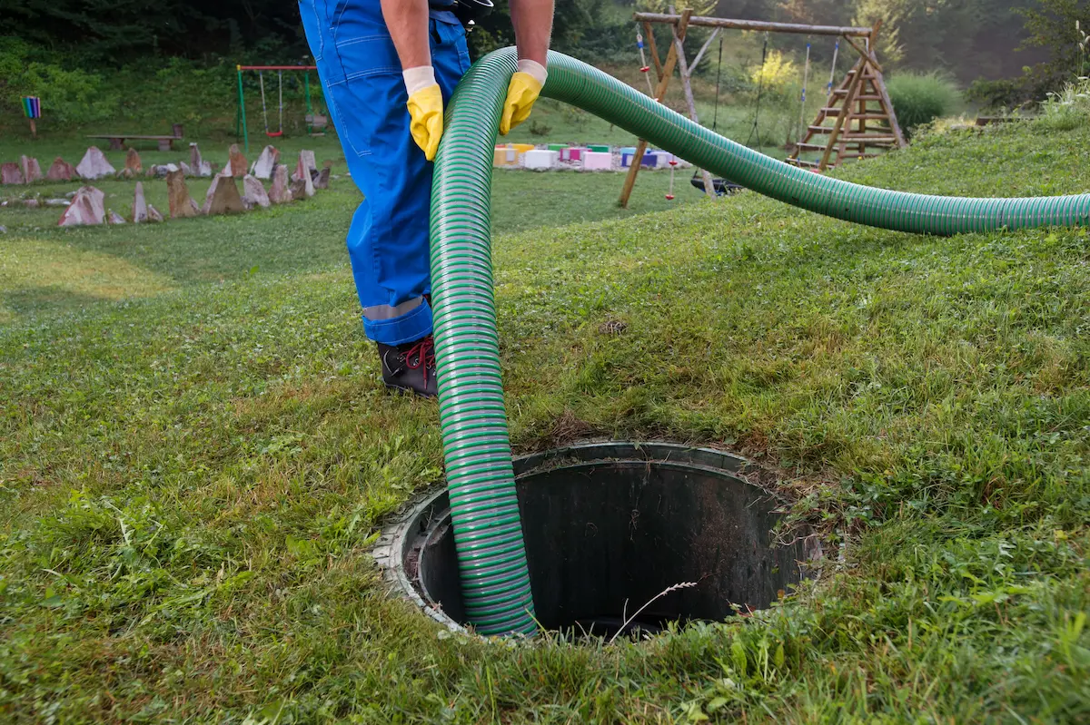 Professional septic tank service truck pumping and cleaning a household septic system representing the professional septic pumping, inspection, and maintenance services that a qualified septic company provides