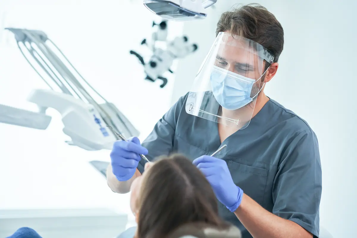 Male orthodontist consulting with a patient in a modern dental office representing the professional and welcoming patient care experience that a quality orthodontic practice provides
