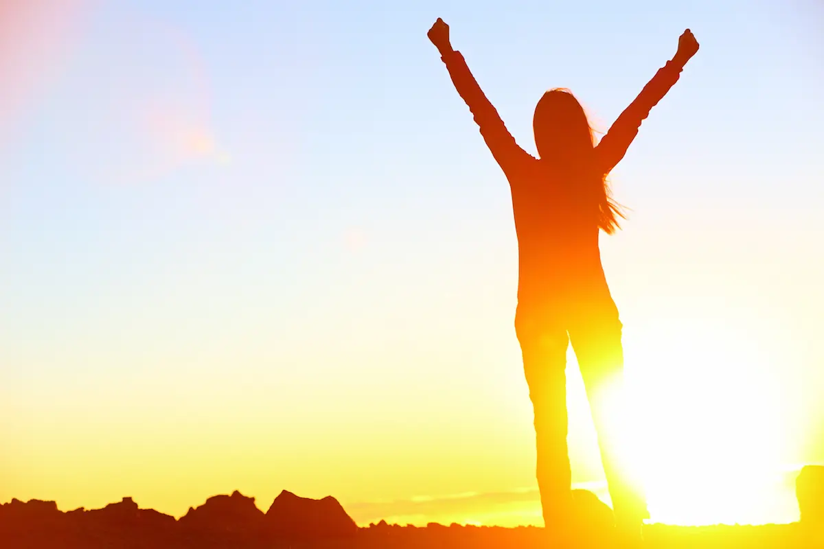A happy and confident woman celebrating a win representing the clarity, growth, and life transformation that a skilled life coach helps clients achieve through personalized coaching work
