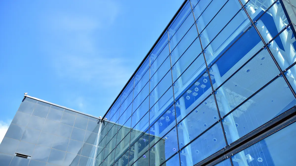 A modern commercial building with blue glass exterior representing the professional and prestigious office environment that a quality office condo association provides for business owners and professionals