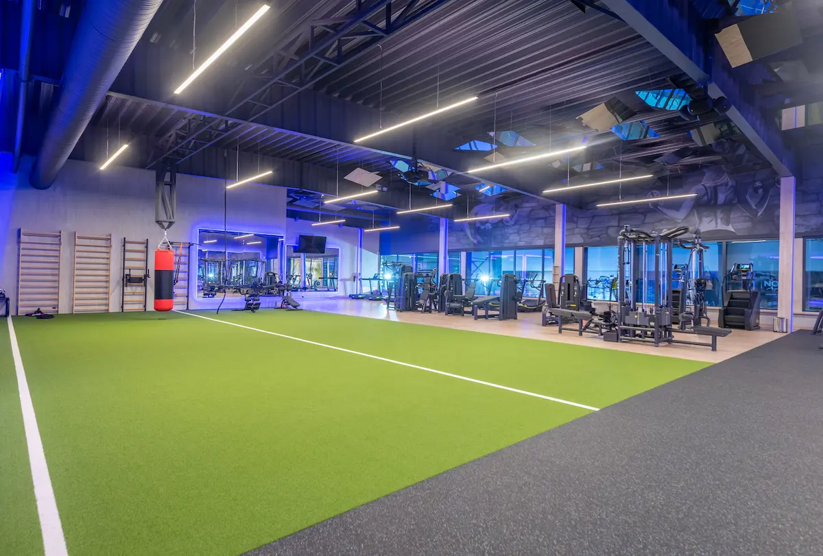 A spacious modern sports and fitness facility featuring a variety of athletic equipment and functional workout areas representing the quality indoor athletic environment that a professional sports complex provides for athletes, teams, and event organizers
