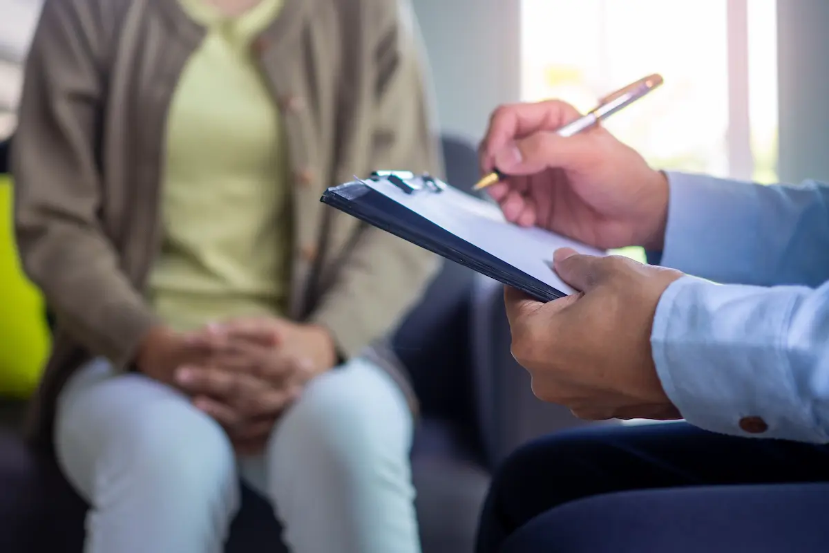 A psychiatrist recording patient mental health symptoms and providing professional clinical advice representing the attentive and evidence-based psychiatric care that a skilled psychiatrist provides for patients managing mental health conditions