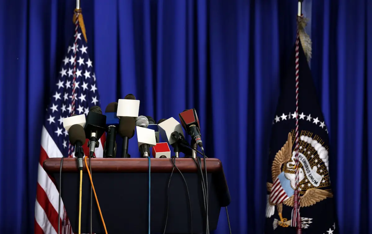 A political candidate at a press conference representing the public presence, clear communication, and credible leadership that a professional campaign website helps establish in every district where voters search for their candidates online