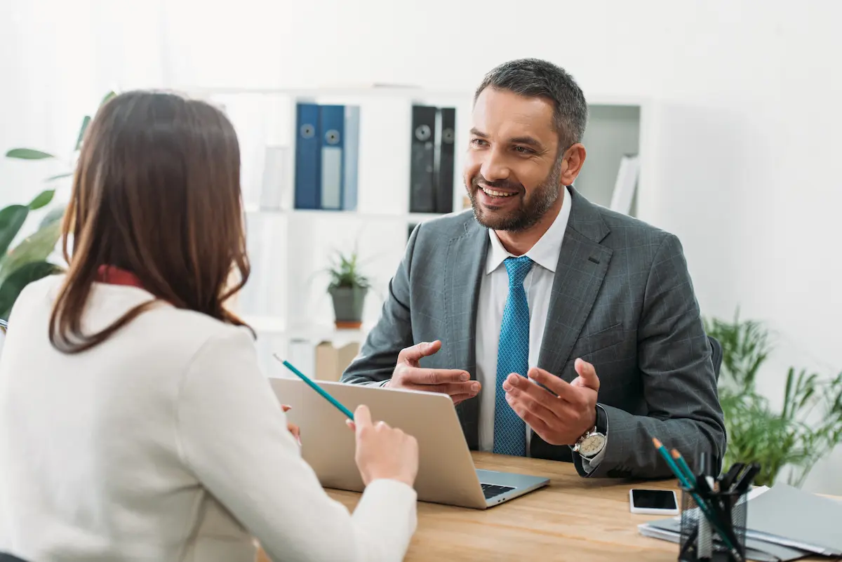 A financial advisor sitting with a client at a desk with a laptop representing the personal consultation, financial expertise, and trusted guidance that a professional financial advisor delivers to every client navigating retirement planning, investment management, and long-term wealth building