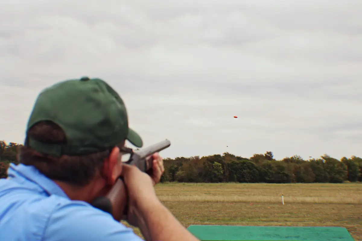 A clay shooting range with an open field and blue sky representing the sport, challenge, and outdoor experience that a great skeet and clay shooting facility provides to recreational shooters, competitive clay shooters, hunters, and corporate group event guests