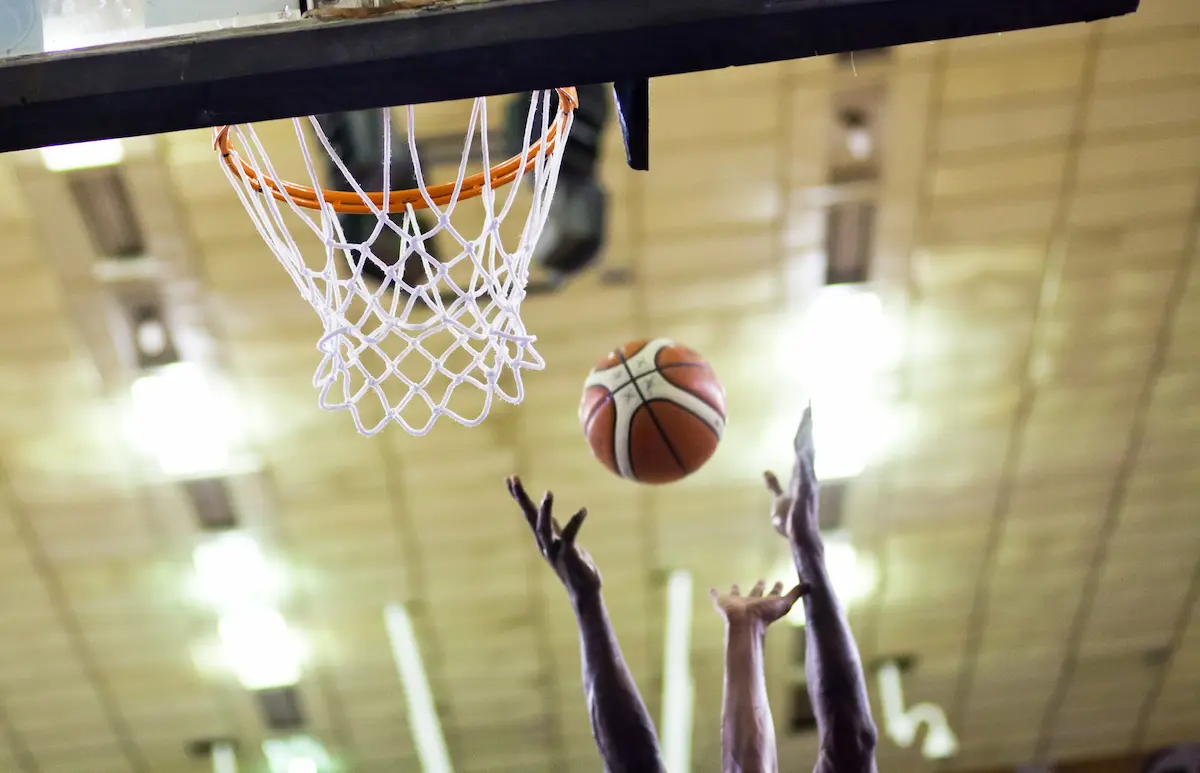 A basketball player scoring the winning points in a game representing the competitive excellence, player development, and team community that a great basketball club provides to every player from recreational beginners to elite travel team competitors