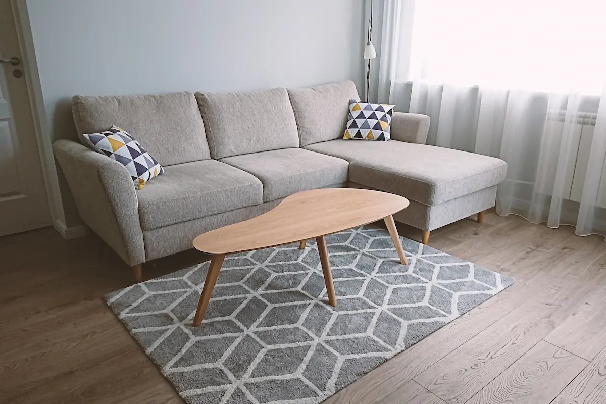 A cozy and light living room with a comfortable beige couch and beautifully restored and refinished wood furniture representing the quality craftsmanship, attention to detail, and transformative results that a professional furniture refinishing business delivers to every homeowner seeking to restore, renew, and protect their cherished furniture pieces