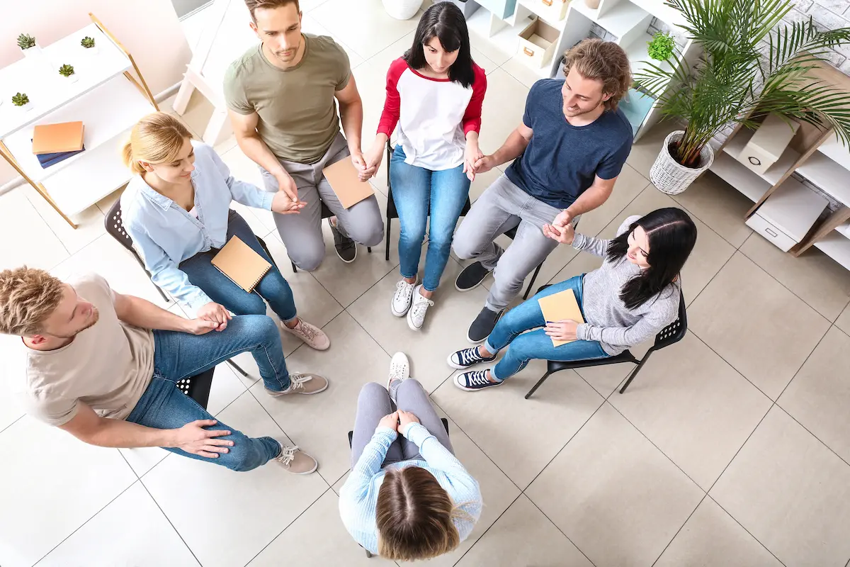 A group therapy session at an addiction treatment center with people sitting in a supportive circle representing the evidence-based treatment, community connection, and compassionate clinical care that a professional addiction treatment program provides to every person on the path to recovery from substance use disorder
