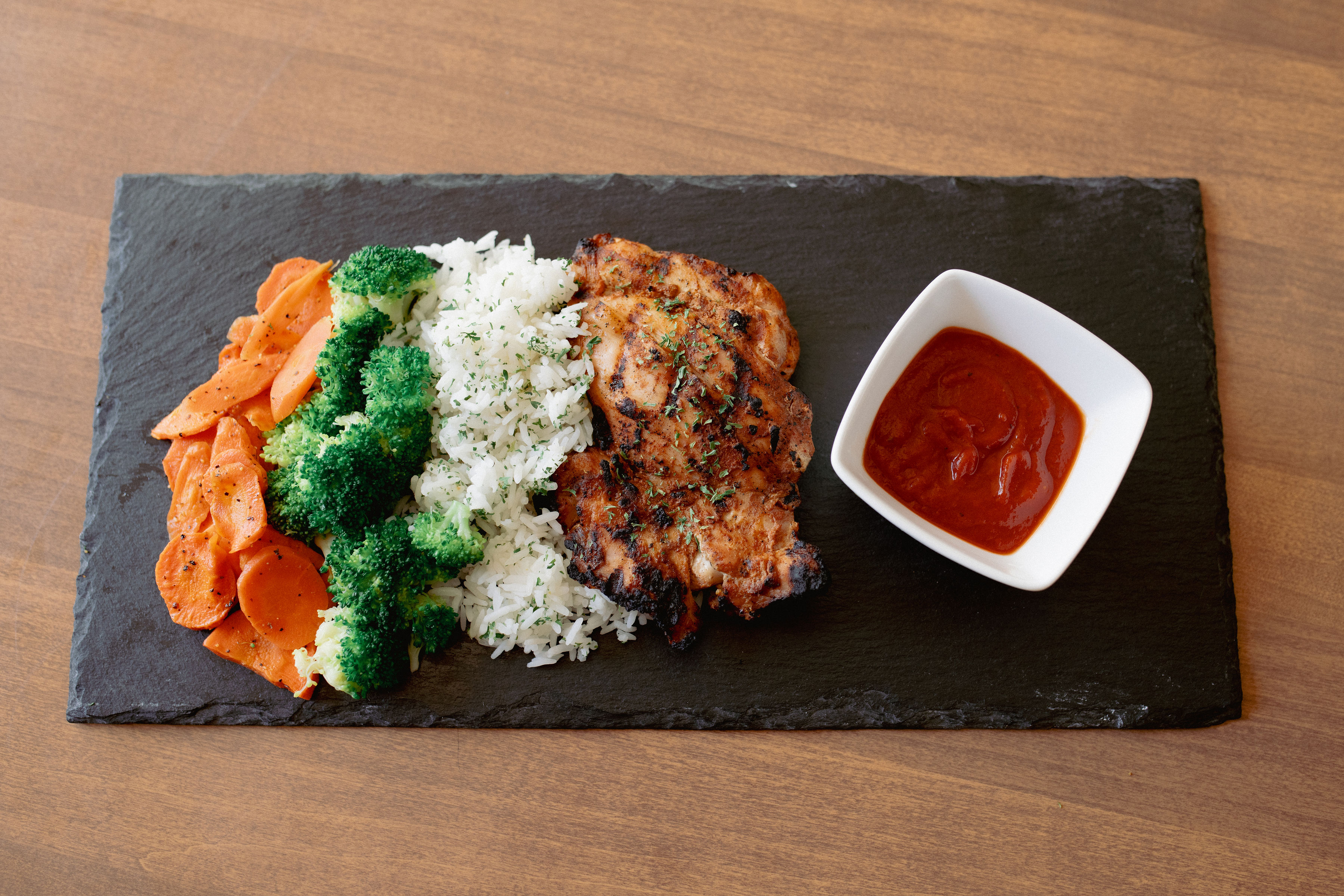 A vibrant Last Bite bowl of grilled chicken, jasmine rice, broccoli and carrots