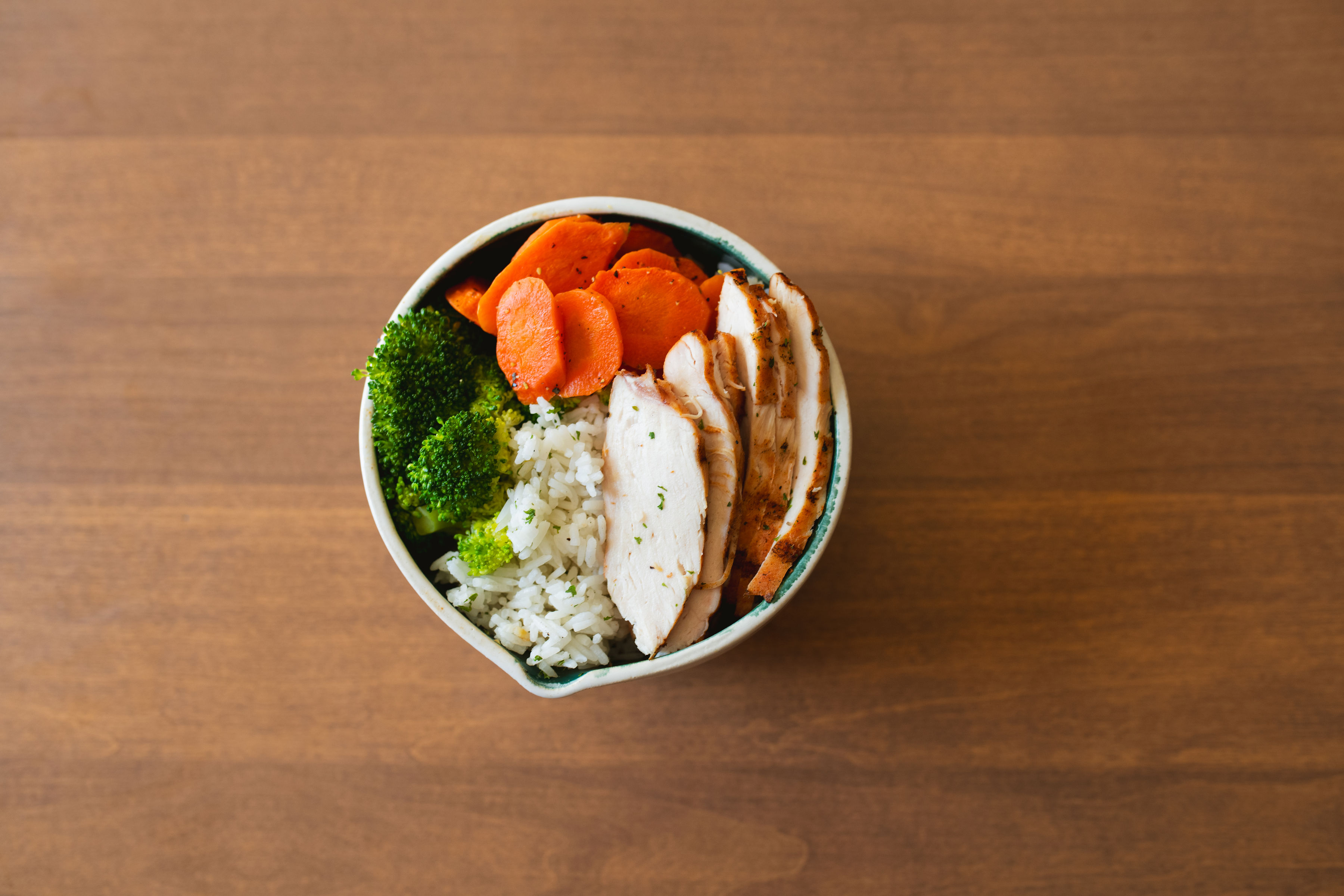 Macro bowl with sliced grilled chicken, jasmine rice, broccoli and carrots